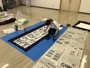 ２尺×８尺の紙に３行書いている女子生徒
